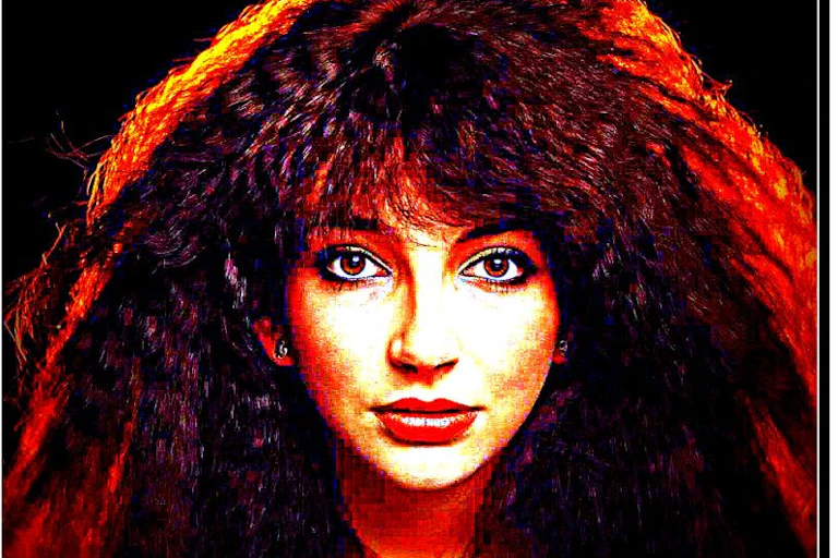 Head and shoulders of a woman with long, back-combed auburn hair.