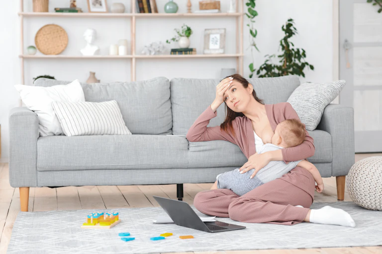 Exhausted mother breastfeeds her baby.