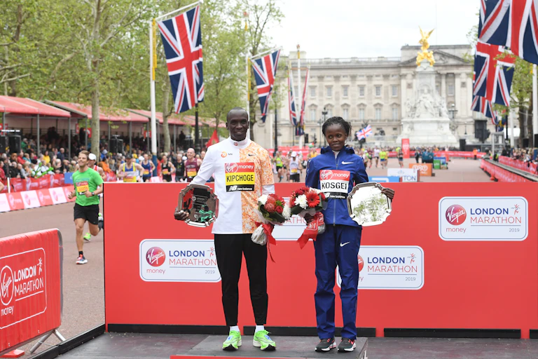 London Marathon men's race winner, Eliud Kipchoge, and women's race winner, Brigid Kosgei pose at the medal ceremony during the 2019 London Marathon.