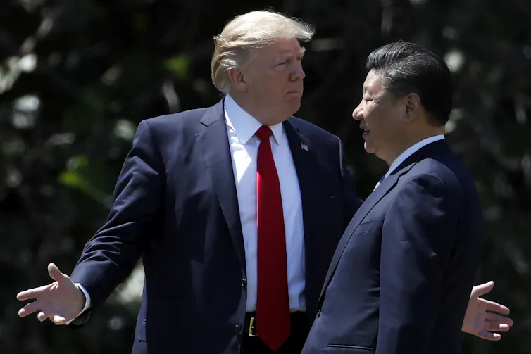 Donald Trump talks to Xi Jinping with arms outstretched