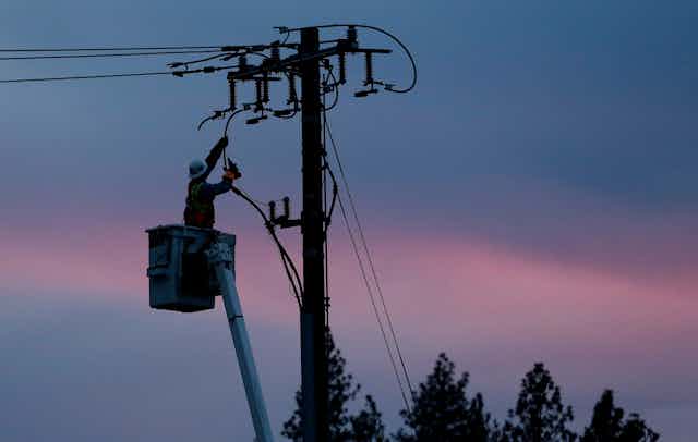 A linesperson works on a electrical utility pole
