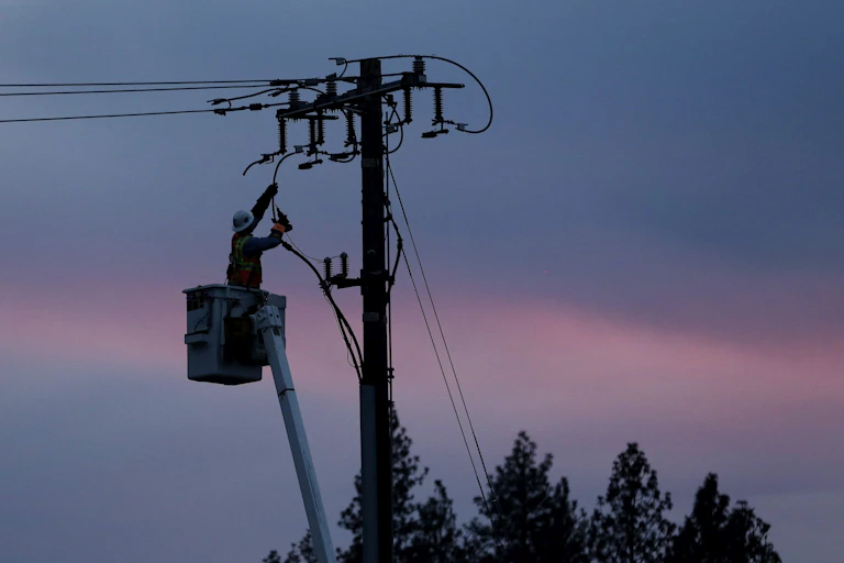 A linesperson works on a electrical utility pole