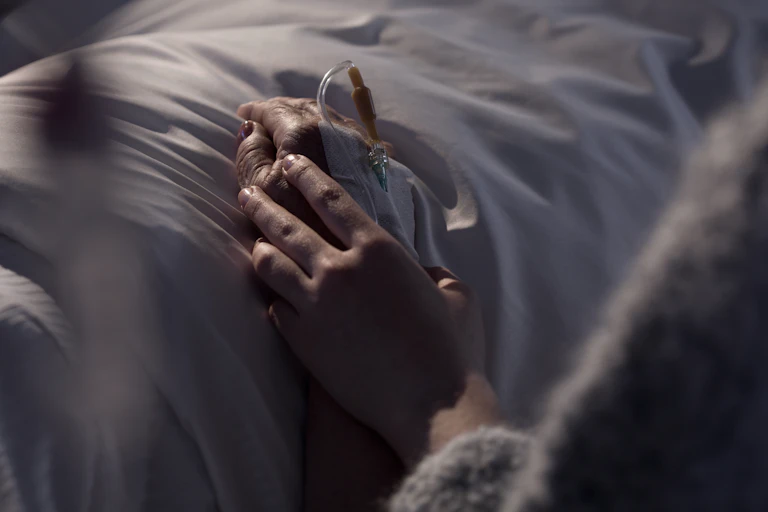 Woman holding hand of a patient