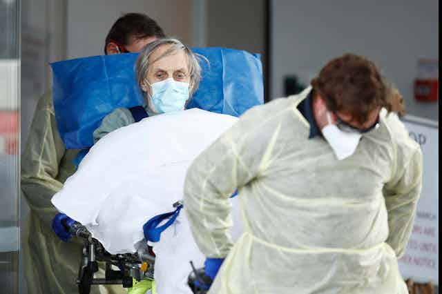 A person is wheeled out of an aged care facility amid the coronavirus pandemic