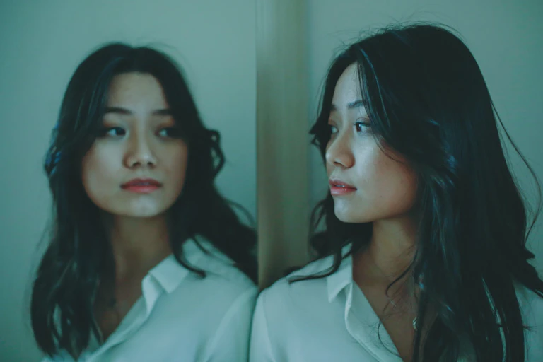 Young asian female looking at reflection