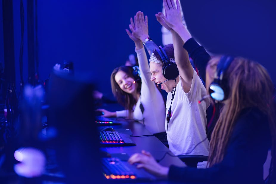 Esports gamers celebrating a victory at their desks
