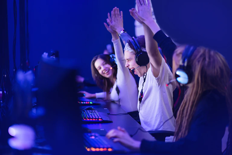 Esports gamers celebrating a victory at their desks