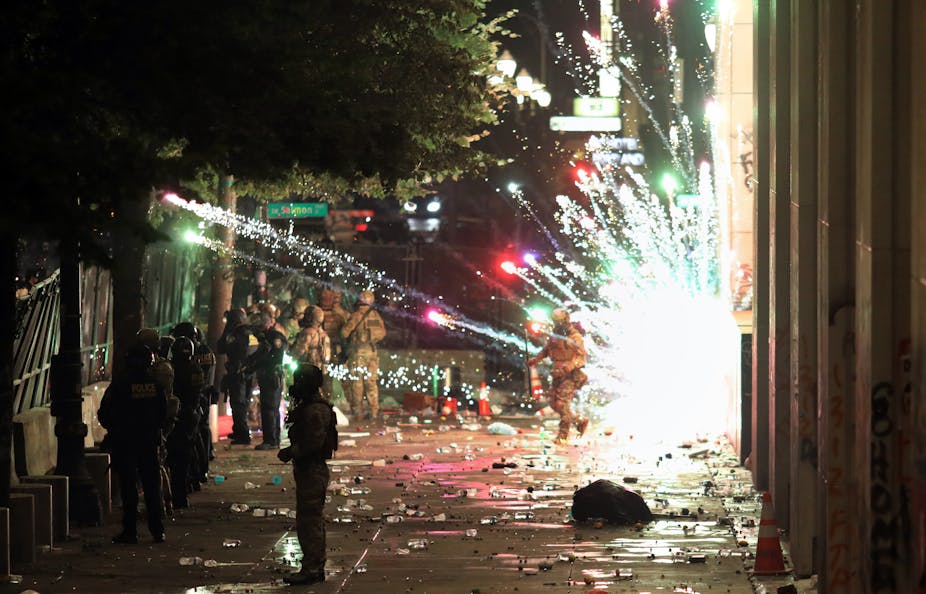 Sparks of an explosion next to policemen