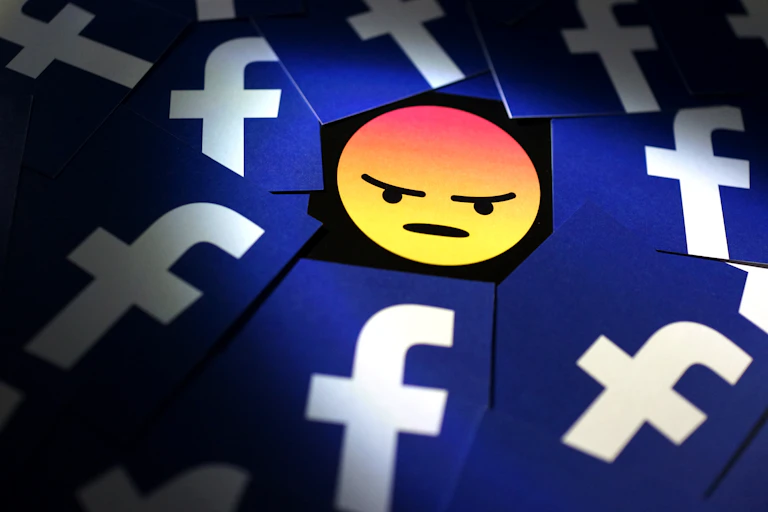 Angry facebook symbol in middle of group of facebook logos