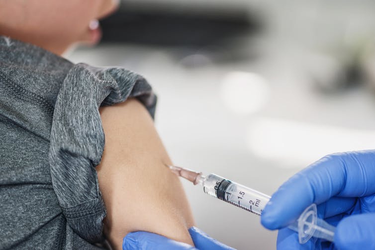 A child receives a vaccination with a needle.