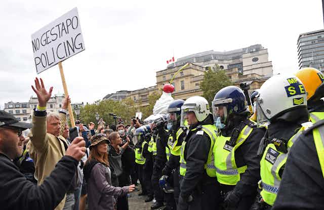 Protestors and police line up in Trafalgar Square. 