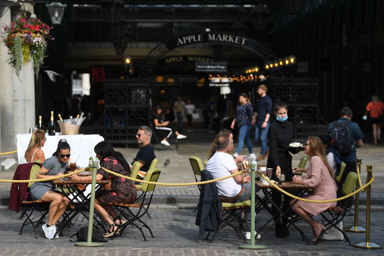 People sit at outdoor restaurant tables.