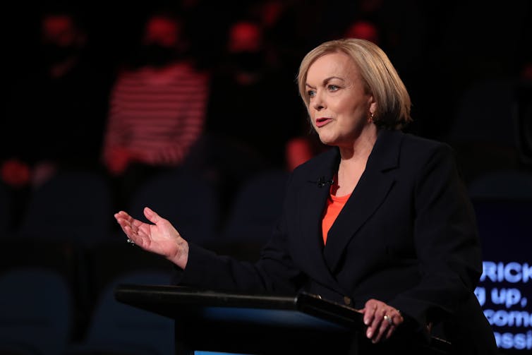 woman at podium gesturing