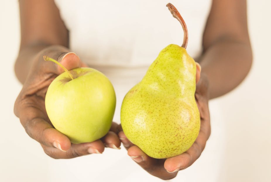Person holding an apple and a pear.