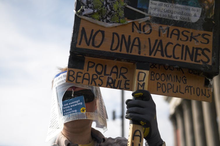 A protester holding a placard with an anti-vaccination slogan