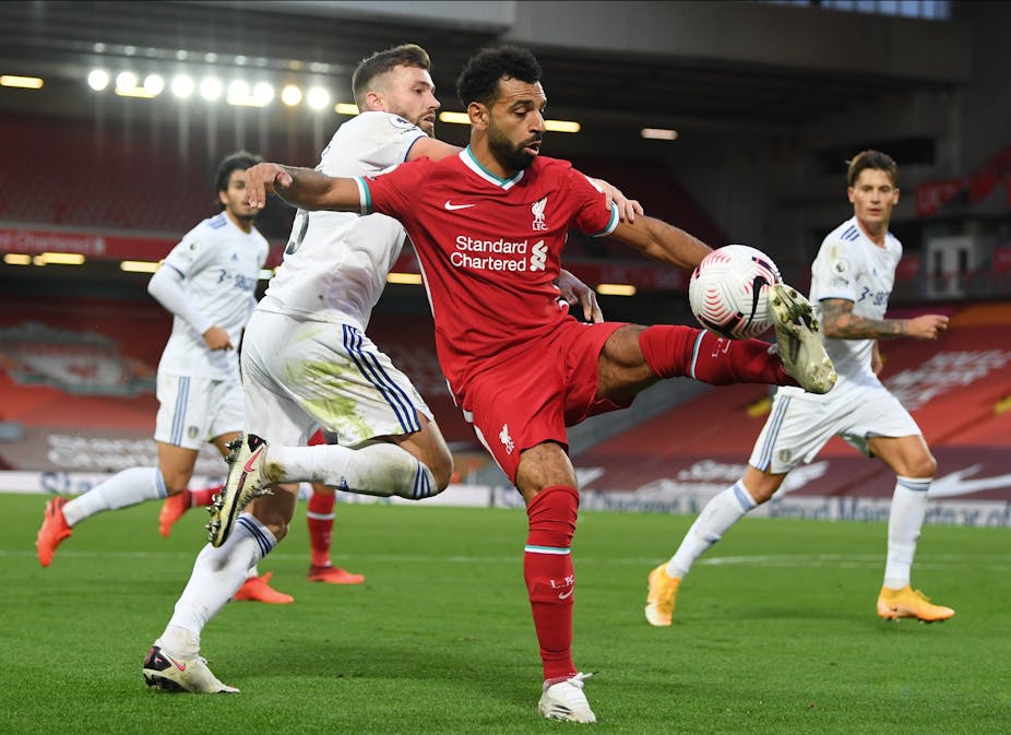 Liverpool's Mo Salah is challenged for the ball by Leeds' Stuart Dallas.