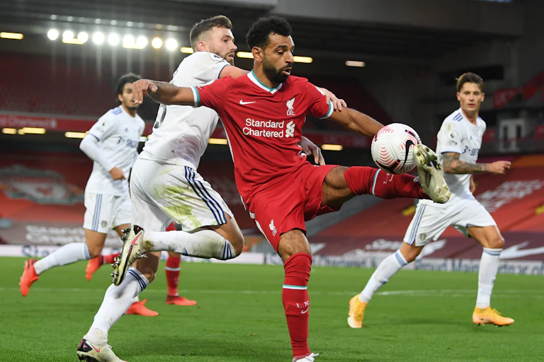 Liverpool's Mo Salah is challenged for the ball by Leeds' Stuart Dallas.