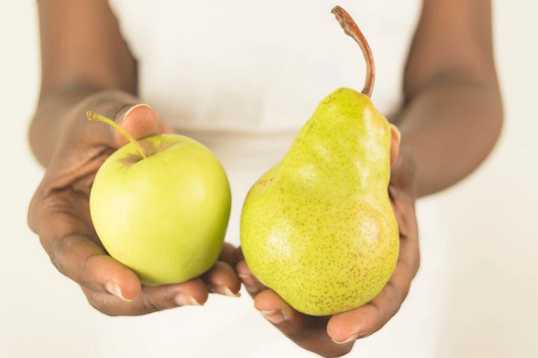 Personne tenant une pomme et une poire.