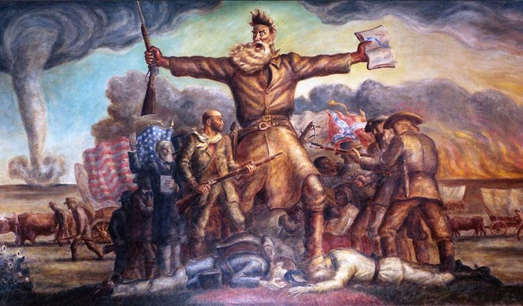John Brown, arms splayed out, triumphantly screams as troops battle behind him.