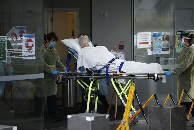 An aged care resident is removed by stretcher from their nursing home.