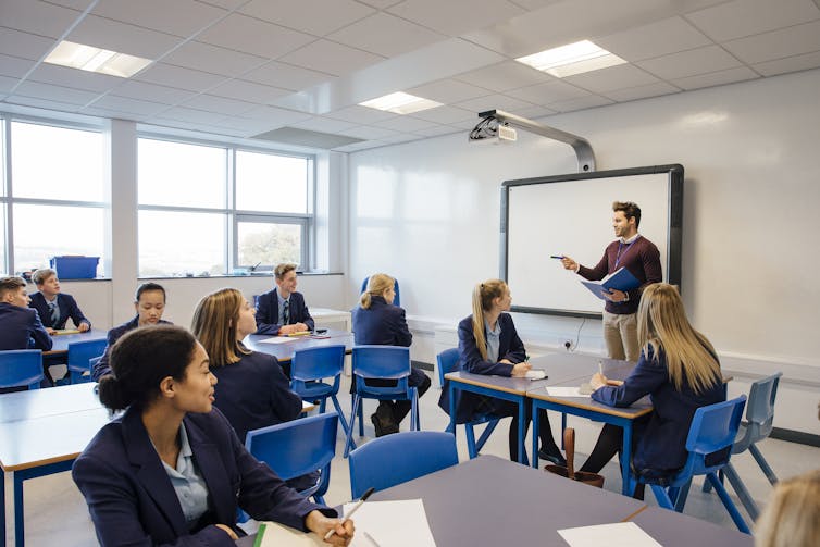 School pupils in uniform sitting in classroom.