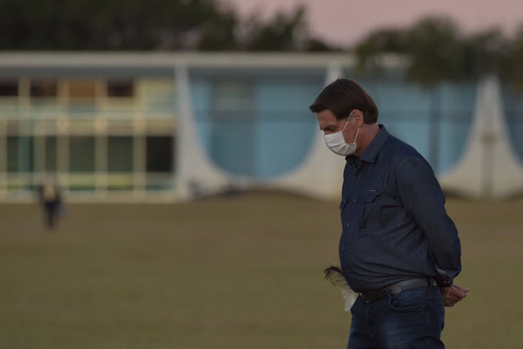 Jair Bolsonaro walking with a mask on