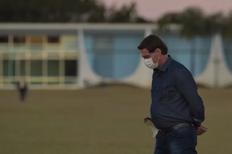 Jair Bolsonaro walking with a mask on
