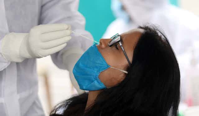A woman having her nose swabbed to test for COVID