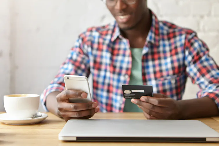 Man using a credit card to pay for something on his phone