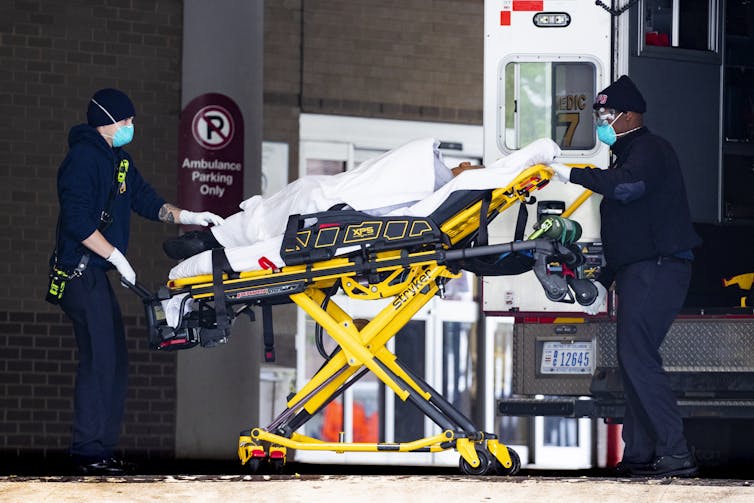 A patient being transferred from an ambulance into hospital on a trolley