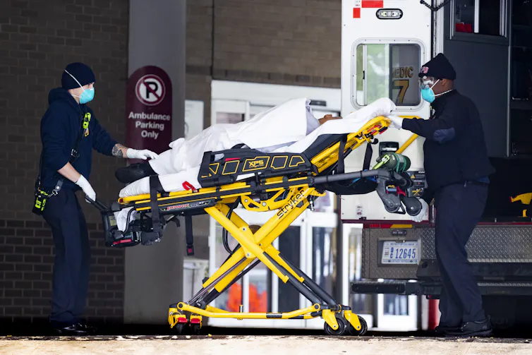 A patient being transferred from an ambulance into hospital on a trolley