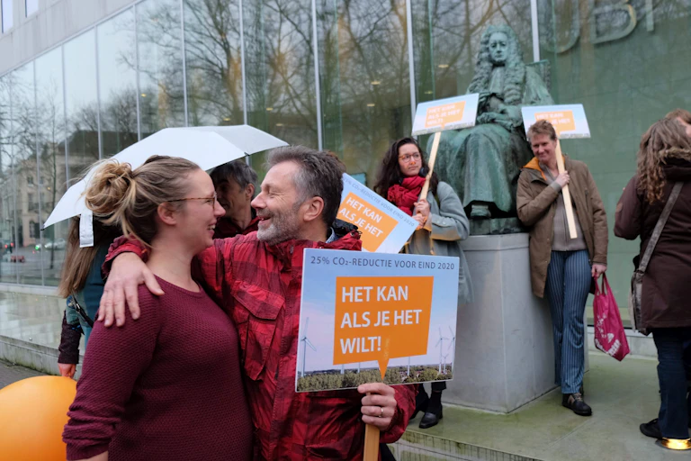 Small group of people holding signs standing outside a building