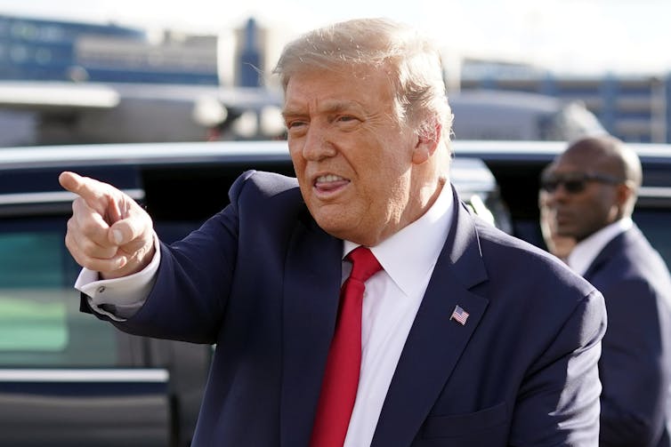 Trump points at a supporter while speaking.