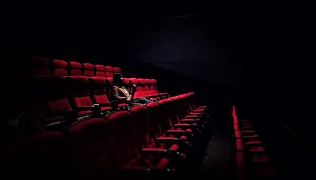 One woman sits in empty theatre