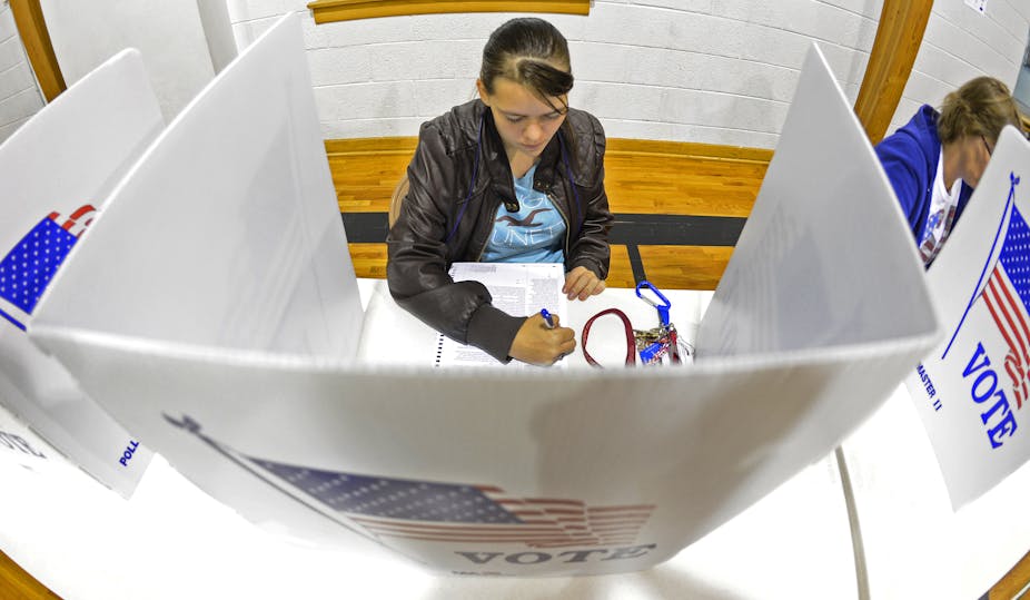 Woman filling in ballot in voting booth