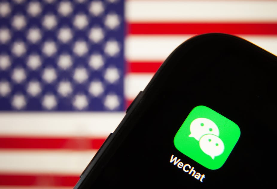 Mobile phone with WeChat app and US flag behind