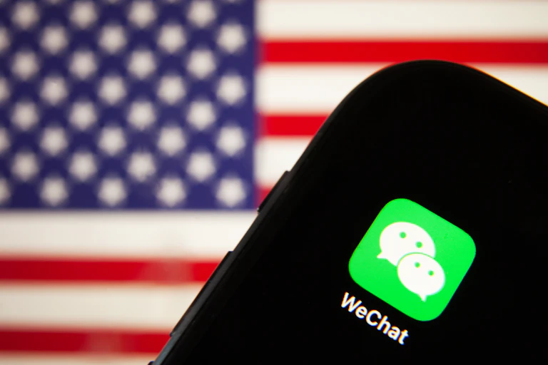 Mobile phone with WeChat app and US flag behind