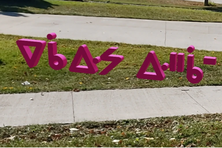 Cree language lettering floating over grass and pavement.