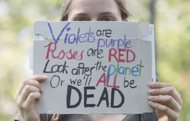 A woman holds up a sign during a climate change protest