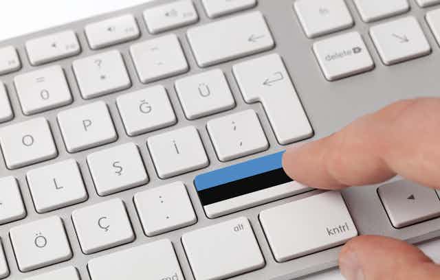 Pressing a key on a keyboard with Estonian flag.