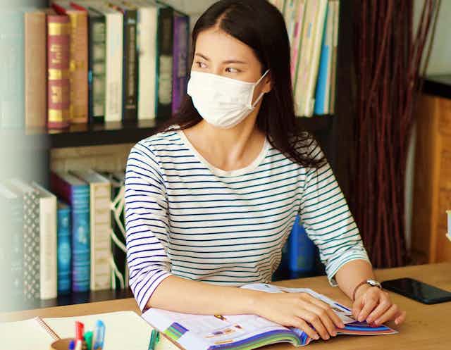 Woman in library wearing mask