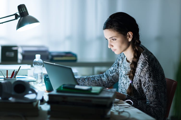 Woman studying with books and laptop