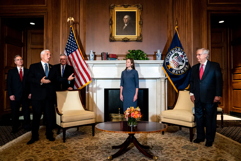 Coney Barrett stands in a stately White House room with Mike Pence and Mitch McConnell, under a portrait of George Washington