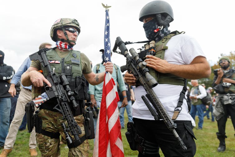 Two people wearing military-like gear