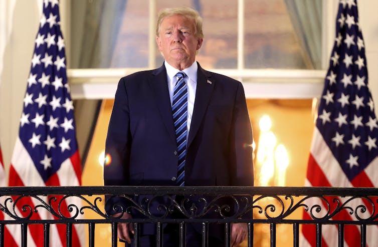 Trump stands, maskless, on the Truman Balcony