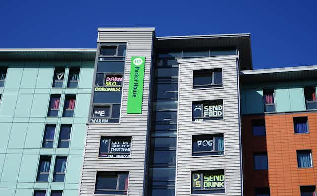 Halls of residence at Dundee University in lockdown with messages on windows saying things like 'Send food and drink'.