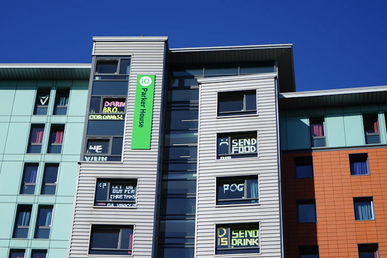 Halls of residence at Dundee University in lockdown with messages on windows saying things like 'Send food and drink'.