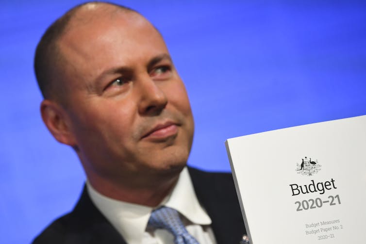 Treasurer Josh Frydenberg holds the 2020-21 budget papers