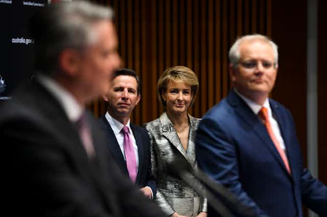Mathias Cormann and Scott Morrison in the foreground, and Michaelia Cash and Simon Birmingham look on in the background