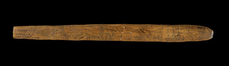Indigenous message stick shows marks and an image of a tall ship.